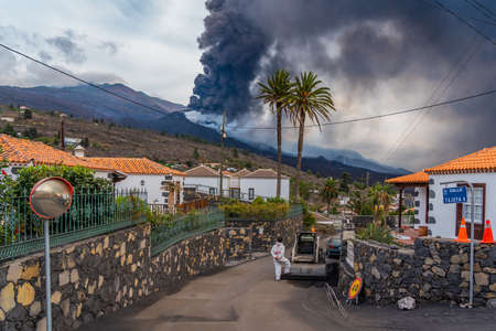 Man looking to the Cumbre Vieja volcano eruption after cleaning the street from ash at the Canary island of La Palma,のeditorial素材