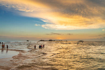 HIKKADUWA, SRI LANKA - DECEMBER 17.2021: Tourist walking along Turtle Beach during sunsetのeditorial素材