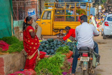 A woman selling fresh herbals on the local Indian vegetable marketのeditorial素材