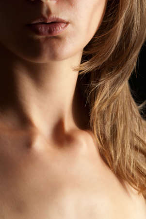 Sexy young woman portrait lips neck dark backgroundの写真素材