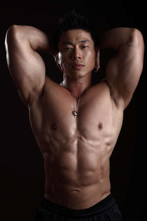 Asian Body Builder Posing flexing looking at the camera