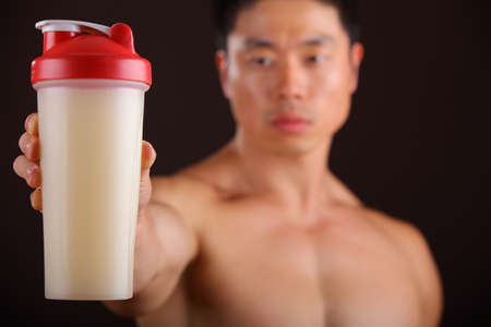 Asian Man holding a Protein Shake Jar he is out of focusの写真素材