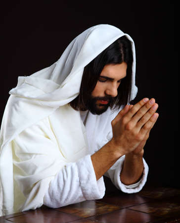 Praying Jesus Christ of Nazareth kneeling hands togetherの写真素材