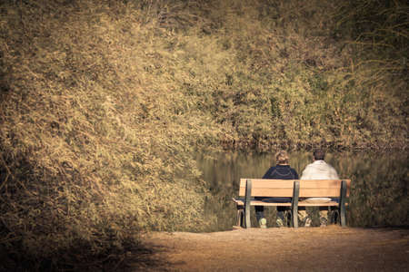 Empty nester older couple sitting on a benchの写真素材
