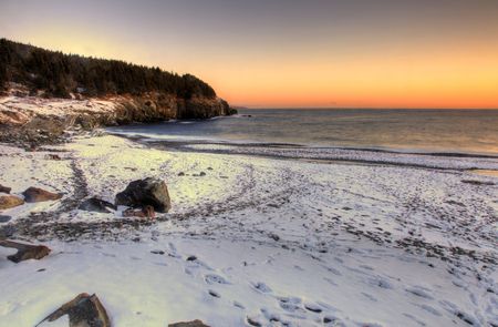 A cold snow covered beach at sunrise.の写真素材