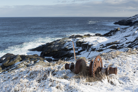 Old winch alone Atlantic coastline in winterの写真素材
