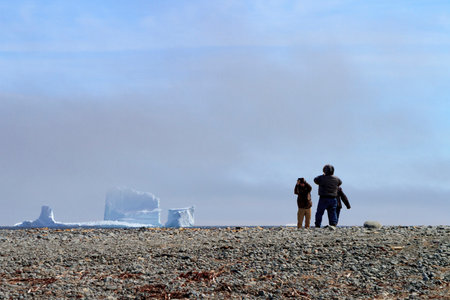 FERRYLAND, NEWFOUNDLAND AND LABRADOR, CANADA - APRIL 16, 2017.  Tourist capturing selfies and images of a majestic iceberg as it passes along the Atlantic Canada coastline, taken on April 16, 2017 in Ferryland.のeditorial素材