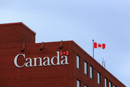 ST. JOHN'S, NEWFOUNDLAND AND LABRADOR, CANADA - JULY 13, 2017.  Flag and sign on a building identifying it as a governemt of Canada building, taken on July 13, 2017 in St. John's.のeditorial素材