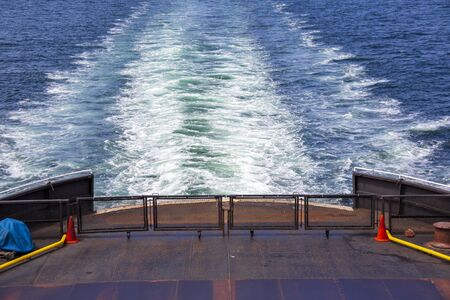 A ferry makes a trail has it moves through the ocean.の写真素材