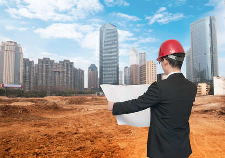 Rear view of architect looking into plans