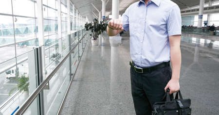 Young Businessman is waiting in the airport waiting hal and he checks the time on his watch.のeditorial素材