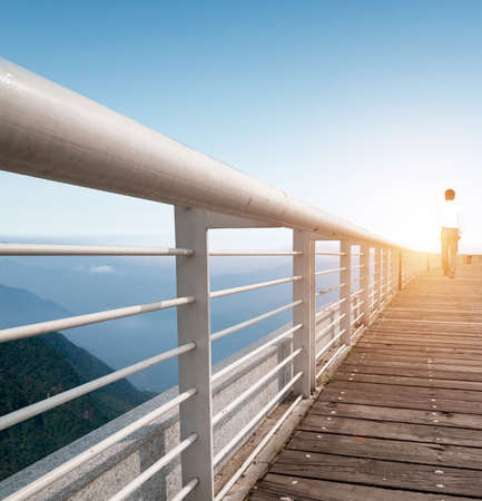 Looking Young Man Cross Bridge Under Morning Sunlightの写真素材