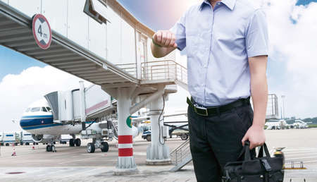 Young Businessman is waiting in the airport waiting hal and he checks the time on his watch.のeditorial素材