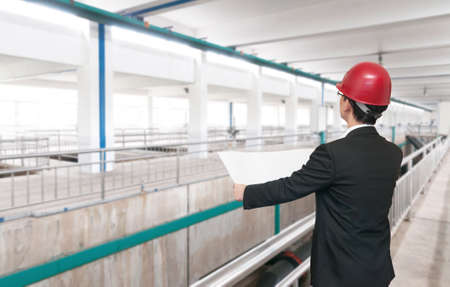 Rear view of architect looking comparing housing project with buildingのeditorial素材