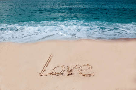 "Love" written on golden sandy beachの写真素材
