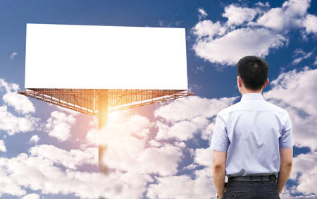 Business person standing near a blank billboardの写真素材