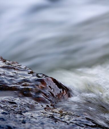 dark wet stone in stream of water