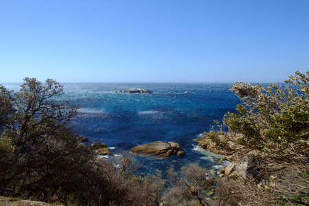 Strong winds wisp the oceans water in the air.の写真素材