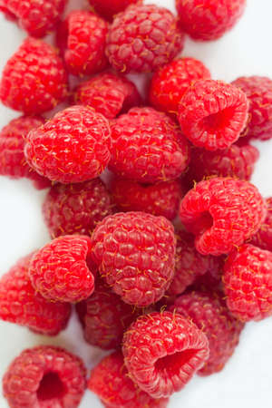 some fresh raspberries over a white background の写真素材