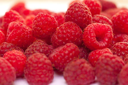 some fresh raspberries over a white background 