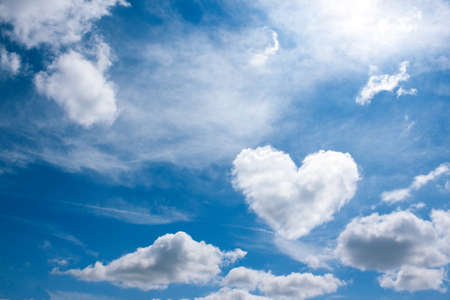 heart cloud on blue sky background. weather or love abstract symbol  with space for textの写真素材