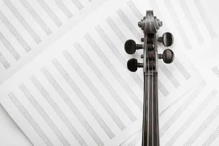Violin neck on sheet with note lines toned photo, classical music backgroundの写真素材