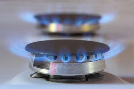 Kitchen gas burners with blue flames of natural gas, domestic equipment with propane or methane gas