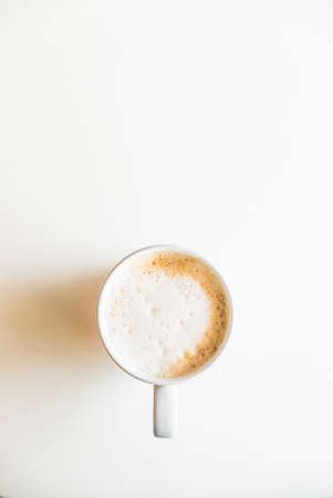 Top of view coffee cup on white table with hard light from side windowの写真素材