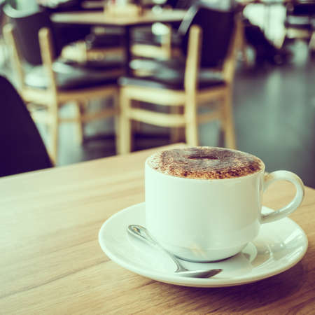 Cappuccino coffee in white cup on table in cafe - Vintage Filterの写真素材