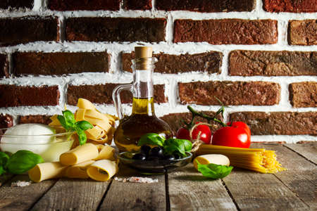 Tasty Colorful Fresh Italian Food Concept with Various Pasta Spaghetti, Cheese Mozzarella, Fresh Basil, Tomatoes, Olive Oil, Spices. Cooking Concept. Place for Text.の写真素材