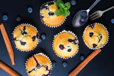 Blueberry muffins with powdered sugar and fresh berriesの写真素材