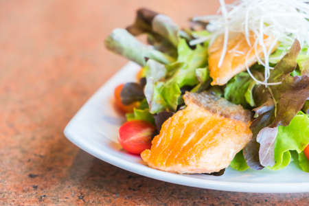 Fried salmon salad with vegetable in white plate - Healthy food styleの写真素材