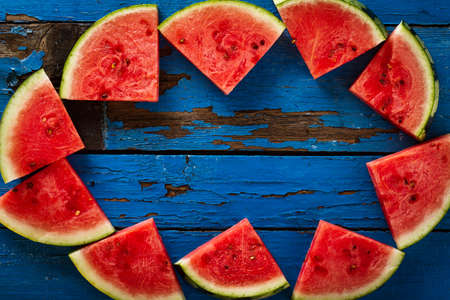 Sliced watermelon Top View. Many slices on an old rustic blue table. Side composition with copy space. Food Backrgound.の写真素材