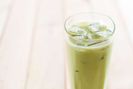iced matcha latte on wood backgroundの写真素材