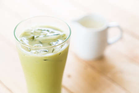 iced matcha latte on wood backgroundの写真素材