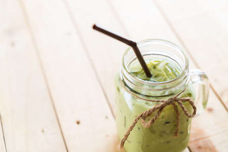 iced matcha latte on wood background