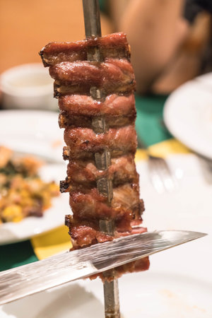 slicing steak brazillian style on plateの写真素材