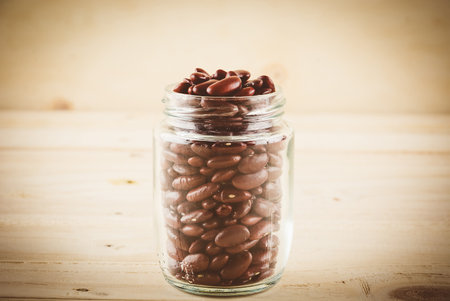 red beans on wood background - soft focus with vintage film filterの写真素材