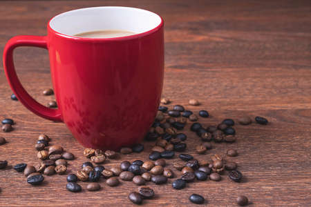 Coffee in a red coffee cup on a wooden tableの写真素材