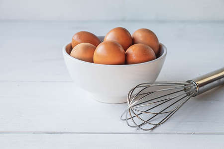 Fresh eggs for cooking on a white wooden table