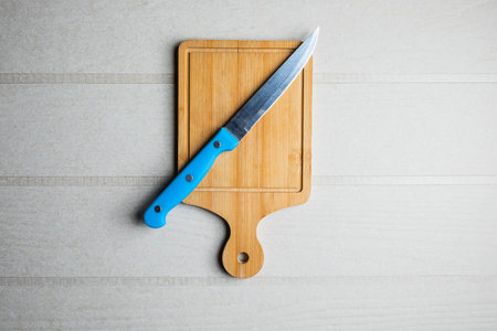 Cutting board and a knife on the tableの写真素材