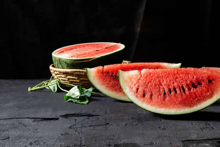 Sliced ripe watermelon on black backgroundの写真素材