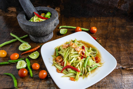 .Cooking Thai food, papaya salad and papaya salad in a dish with a serving on a wooden table.の写真素材