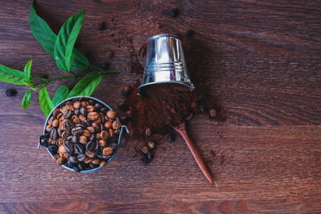 .Roasted coffee beans and coffee powder on a wooden tableの写真素材