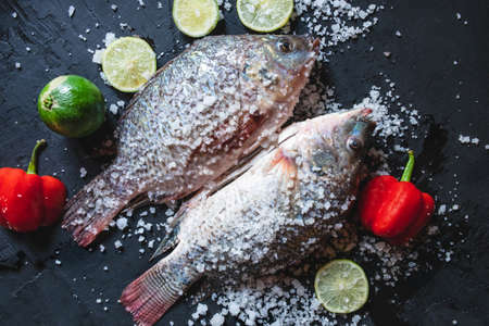 Fresh fish of tilapia with salt and seasoning for cooking.の写真素材