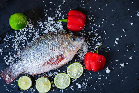 Fresh fish of tilapia with salt and seasoning for cooking.の写真素材