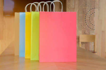 Colorful paper shopping bags on wooden tables for women. concept fashion and shoppingの写真素材