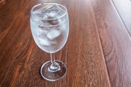 Glass with water and ice on the table