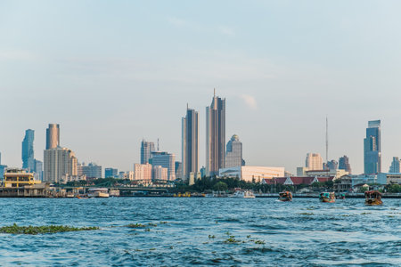 Landscape view of buildings at the Chao Phraya riverside and boats in the river. Bangkok, Thailand.の写真素材