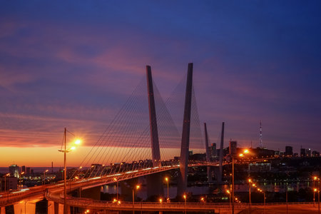 Vladivostok, Primorsky Krai. Golden bridge on the background of the magnificent dramatic sky at sunsetの写真素材